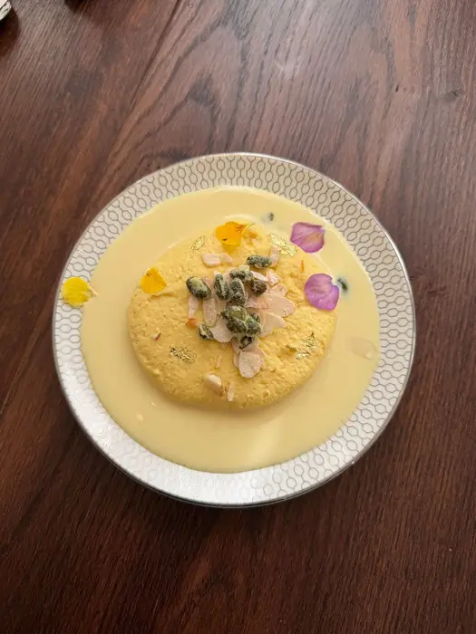 Traditional Indian Rasmalai dessert with pistachios and rose petals